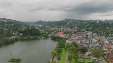 Kandy 'nin sakin cazibesini ve doğasını yukarıdan yansıtıyor. Gökyüzünün altında manzaralı bir yapay göl, yeşillik ve şehir binaları..