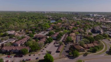 Açık bir gökyüzü altında evleri, ağaçları, yolları ve şehirleri olan Wichita 'da bir yerleşim bölgesinin havadan görünüşü, banliyö yaşam ve emlak olanaklarını gözler önüne seriyor..