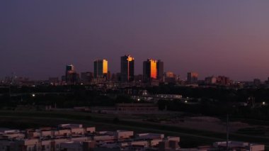 Gün batımında Fort Worth 'un gökyüzü manzarası, ön plandaki konut binaları, gün geceye dönerken altın renklerle yıkanmış..
