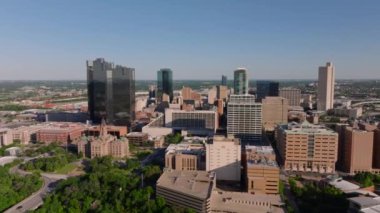 Fort Worth 'un gökdelenleri, yüksek binaları ve Teksas' ın şehir merkezindeki yemyeşil çevresiyle gökyüzü manzarası.