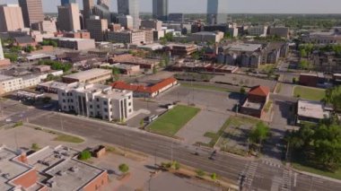 Oklahoma şehrinin dinamik ufuk çizgisi kuşbakışı, güneşli bir günde şehir manzarasını ve yeşil alanları vurguluyor..