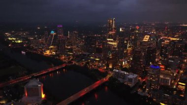 Geceleri Austin şehir merkezinde aydınlatılmış köprüleri ve gökdelenleri yakalıyor Colorado nehrinin sakin sularına yansıyan ışıkları yansıtıyor..