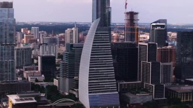 Austin, Teksas şehir merkezindeki hava manzarası. Blok 185 gökdelen ve bulutlu gökyüzünün altındaki inşaat alanları. Modern mimari ve kentsel gelişim devam ediyor.