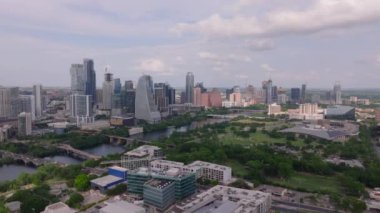 Gökdelenlerle, yeşil ağaçlarla ve bulutlu bir gökyüzünün altındaki nehirle Austin 'in gökyüzü manzarası. Şehir manzarası şehirdeki dingin doğayla buluşuyor..