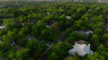 Austin, Teksas 'ın havadan görünüşü, şehrin dış mahallelerindeki yeşil mahallelerin arka planına karşı modern ufuk çizgisini yakalıyor..