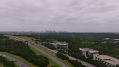 Bulutlu bir gökyüzünün altında hava manzaralı otoyollar. Austin, arka planda Teksas 'ın canlı başkenti. Kentsel altyapı kavramı.