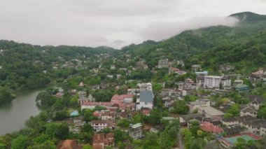 Kandy, Sri Lanka, yemyeşil tepeler, pitoresk göl ve bulutlu gökyüzünün altındaki şehir manzaraları. Asya 'daki bu tropikal şehrin güzelliği.