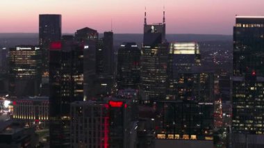 Alacakaranlıktaki Nashville şehir manzarası, ATandT Binası ve canlı şehir silueti de dahil olmak üzere aydınlık gökdelenler. Şehir güzelliğini ve modern mimariyi vurgulamak için ideal. Nashville