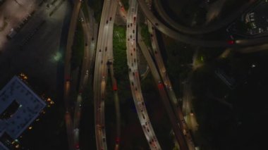 Geceleri Amerikan şehirlerinin hava manzarası karayollarını aydınlatarak ulaşım sistemi, altyapı ve trafik akışını vurguluyor..