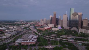 Houston 'ın alacakaranlıktaki gökdelenleri, otoyolları ve şehir manzarasını gösteren gökyüzü manzarası modern mimariyi ve şehir hayatını ön plana çıkarıyor..