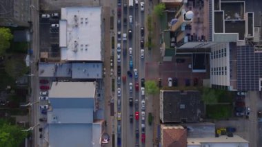 Bir Amerikan şehrinde trafik sıkışıklığı olan işlek caddenin kuş bakışı görüntüsü, şehir manzarasını ve binalar arasında akan arabaları gösteriyor.