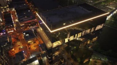 Nashville şehir merkezinin parlak gece manzarası, aydınlık sokaklar, binalar, ve nehir üzerinde John Seigenthaler Köprüsü.