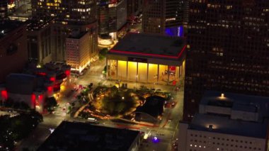 Houston Senfoni Orkestrası 'nın evi olan Jones Hall' un üzerinde gece süzülerek diğer aydınlık binalar, canlı sokaklar ve güzel aydınlatılmış şehir manzarası sergileniyor. Houston, Teksas, ABD