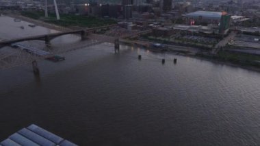 St. Louis 'in ikonik geçit kemeri, Mississippi Nehri ve şehir manzarasıyla alacakaranlıkta gökyüzü manzarası şehir güzelliklerini ve seyahat noktalarını gözler önüne seriyor..