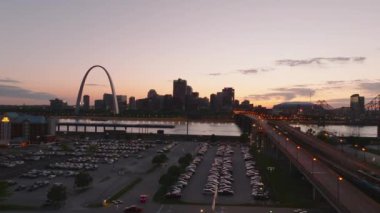 Gün batımında St. Louis 'in hava manzarası, sıcak ışıkla Mississippi Nehri boyunca ikonik geçit kemeri ve canlı şehir manzarasını gösteriyor. St. Louis, Missouri, ABD, 10 Nisan 2024