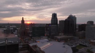 Kansas 'ın merkezinde canlı bir güneş doğuyor. Güneş ışığı gökdelenleri ve endüstriyel binaları aydınlatarak, sabah gökyüzüne karşı çarpıcı zıtlıklar ve siluetler yaratıyor. Kansas City, Kansas, ABD