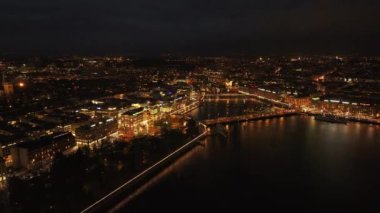 İsviçre 'deki Cenevre' nin canlı ışıklarının havadan görünüşü Rhone Nehri 'ndeki aydınlatılmış binaları ve yansımaları gösteriyor. Mont Blanc köprüsü çevresindeki yoğun kentsel ortam gece hayatını vurguluyor.