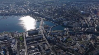Cenevre 'nin havadan görünüşü şehir manzarasını ve sakin Lac Leman' ı gün ışığını yansıtıyor, yukarıdan şehrin güzelliğini vurguluyor..
