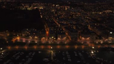 Gece Genevas rıhtımının görüntülerini izlemek, caddelerdeki trafiği yakalamak ve yat limanına yanaşan tekneleri yakalamak..
