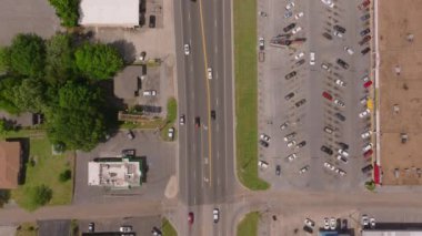 Laurel, ABD 'de bir otopark ve ana yolun havadan görüntüsü. Yüksek açılı araçlar ve binalar, bu küçük Amerikan kasabasının şehir yaşamını ve trafiğini yakalıyor..