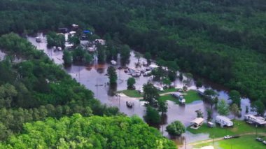 Louisiana 'nın sık ormanlarla çevrili otoparkının havadan görüntüsü. Mobil evler ve araçlar kısmen suya batmış..