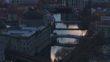 Berlin şehir merkezindeki gün batımını yansıtan Spree nehrinin üzerinde duran köprüler İHA görüntüleri ve kuş bakışı görüntülerle resmedilmiştir..