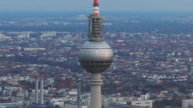 Alexanderplatz 'daki Berlins TV kulesinin arka planda şehir manzaralı insansız hava aracı görüntüleri. Alman başkentindeki ikonik yapının hava görüntüsü.