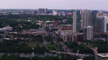 Gökdelenler, parklar ve şehir güzelliğini ve çağdaş yaşamı aydınlatan huzurlu bir nehir ile Austin, Teksas şehir merkezinin alacakaranlık manzarası..