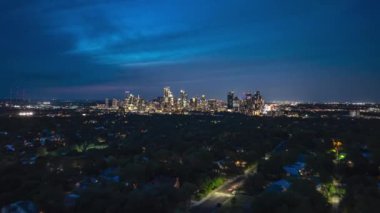 Austin, Teksas 'ta alacakaranlıktan geceye hiperlapse kayar. Gökyüzü karardıkça şehir ışıkları canlanıyor, modern şehir merkezindeki gökdelenleri aydınlatıyor..