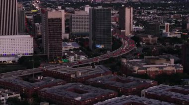 Gece şehir merkezindeki Houstons 'un hava görüntüsü modern gökdelenlerin altındaki işlek caddeleri, renkli şehir ışıklarını ve trafik ışıklarını yakıyor..