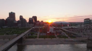 St. Louis, Missouri üzerinde çarpıcı bir gün doğumu. Canlı renkler şehrin ufuk çizgisini, köprüleri, Mississippi Nehri 'ni ve limanı aydınlatıyor..