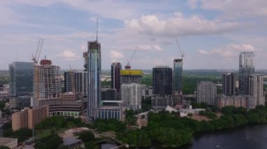 Austin, Texas şehir merkezinin gökdelenleri, vinçleri ve inşaat projeleriyle hava manzarası. Canlı şehir manzarasında modern binalar ve yeşil alanlar.