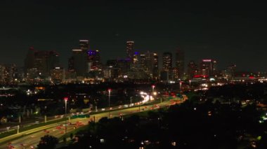 Houstons 'un gece gökdelenler ve hareketli ışık yollarıyla dolu gökdelenleri gösteren gökyüzü manzarası. Texas 'ta modern mimari ve canlı bir atmosfer var..