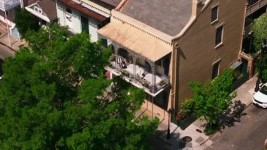 New Orleans 'ta ikonik terası, yeşilliği ve klasik mimarisi olan tarihi binaları gösteren pitoresk bir caddenin havadan görünüşü..