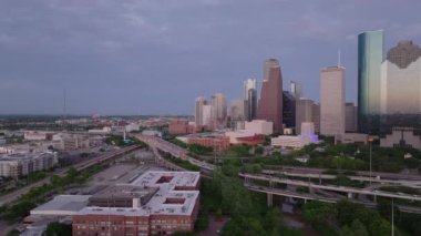 Houston alacakaranlıkta gökdelenleri ve Körfez Otobanı 'nı aydınlatırken, şehir manzarası geceye dönerken.