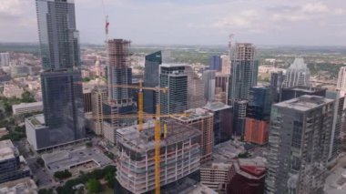 Gökdelenleri, inşaat alanları ve şehir manzarası olan Austin şehrinin hava manzarası açık bir günde. Canlı şehir hayatı ve modern mimari sergileniyor. Austin, ABD, 10 Nisan 2024