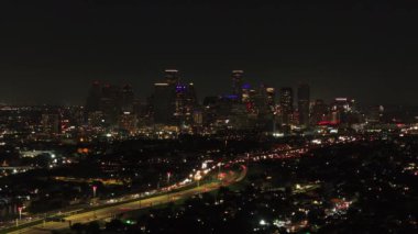 Houstons 'un nefes kesen hava manzarası geceleri canlı şehir merkezinde gökyüzü, şehir ışıkları ve aşağıdaki otobanlarda hareketli trafik var..