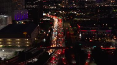 Gece Houstons otobanı havadan görünüyor, parlak şehir ışıkları ve yoğun trafik var. Şehir manzarası ve aydınlatılmış şehir manzarası hareketli bir metropolde..