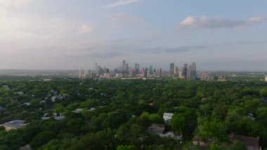 Austin, Teksas 'ın günbatımında gökyüzü manzarası, yemyeşil ve mahallelerle çevrili, şehrin güzelliğini ve kentsel manzarasını gözler önüne seriyor..