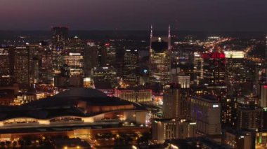 Alacakaranlıkta canlı Nashville silueti, parlayan gökdelenler ve şehir merkezindeki işlek sokaklar şehir ışıklarıyla nefes kesici bir hava perspektifiyle. Nashville, Tennessee, ABD, 10 Nisan 2024