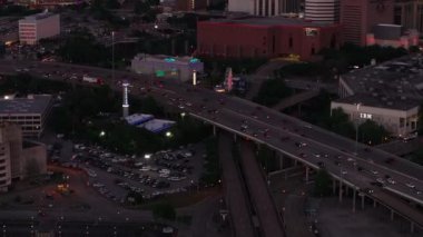 Houston 'ın alacakaranlıktaki hava manzarası, şehrin ışıklarını yakalamak, hareketli otoyollar, ve çağdaş şehir manzarası. Kentsel, şehir veya seyahat temaları.