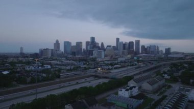 Houston gökyüzü alacakaranlıkta, şehir merkezindeki modern binaların ve otoyolların karışımının altını çiziyor..