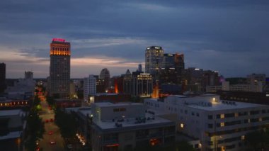 Birmingham, ABD şehir merkezindeki gökdelenin hava görüntüsü, şehir ışıkları ve caddelerdeki trafik ve alacakaranlıktan geceye geçiş yapan ufuk çizgisi. Birmingham, Alabama, ABD, 10 Nisan 2024