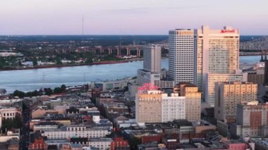 Gün batımında New Orleans 'ın havadan görünüşü, şehrin ufuk çizgisini, rıhtımın önünü, Crescent City Connection' ı ve Mississippi Nehri 'ni gün geceye dönerken görüntülüyor. New Orleans, Louisiana, ABD, 10 Nisan 2024