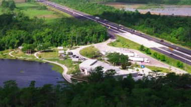 Louisiana 'daki bir otobanın havadan görünüşü dinlenme alanı, su hatları ve geçen araçlar. Seyahat ve ulaşım kavramları.