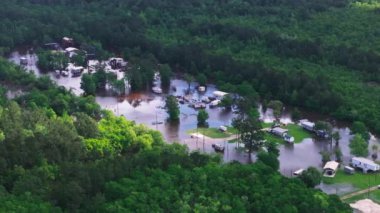 Louisiana 'da su altında kalmış bina ve araçlarla dolu bir kamp alanının havadan görüntüsü. Yeşillik ağaçlı doğal afetin sonucu.