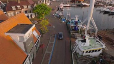 Avrupa 'nın sakin kıyı kasabasında balıkçı tekneleri ve büyüleyici rıhtım binalarıyla Urk limanının havadan görünüşü.