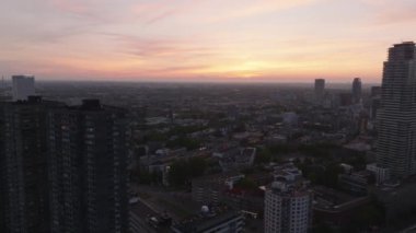 Gün batımında Rotterdam 'ların şehri canlı bir gökyüzüne karşı yüksek binalar sergiliyor. Şehir yoğunluğu ve mimari çeşitlilik yukarıdan.