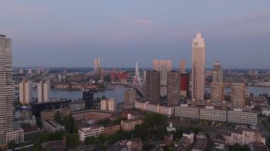 Rotterdam 'ın günbatımında gökyüzü manzarası modern mimariyi ve hareketli şehir yaşamını ön plana çıkarıyor. Kentsel ve mimari temalar için ideal.
