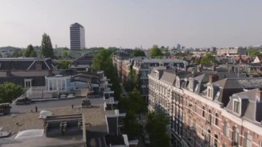 Ağaç kaplı caddeleri, konut binaları ve uzak bir gökdelenle büyüleyici bir Amsterdam mahallesinin havadan görünüşü kent cazibesini ve Avrupa mimarisini gözler önüne seriyor..
